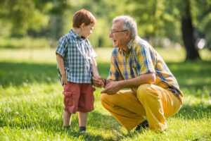 Grandfather listening to grandson in park